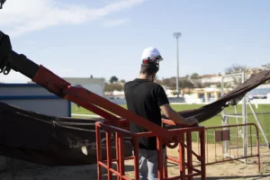 Liège granulé pour le remplissage de terrains de sport - un ouvrier au travail